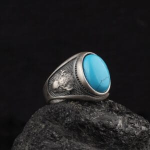 bison head ring is a jewelry that has a blue gemstone on top of it and bison head ornaments on the band